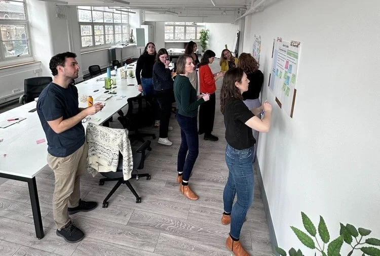 People in office looking at notes on a wall