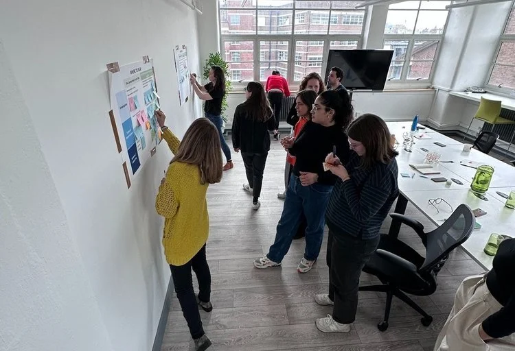 People in office looking at notes on a wall