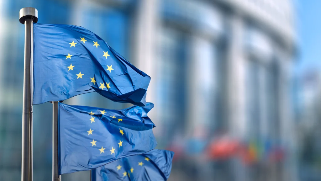 Three EU flags with an official building in background