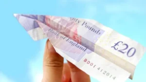 £20 note (GBP) folded into a paper plane.
