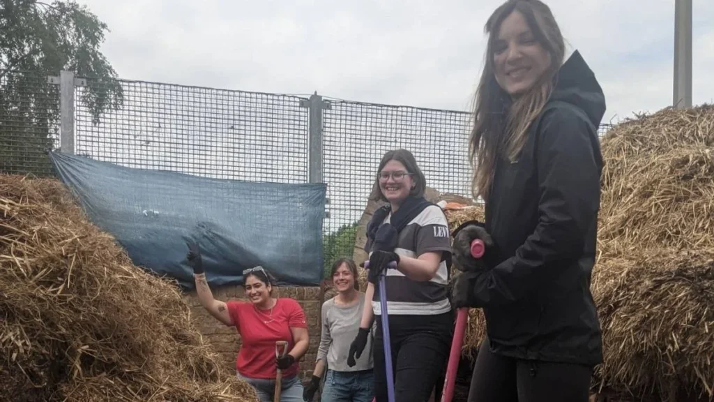 Four women at a farm surrounded by hay