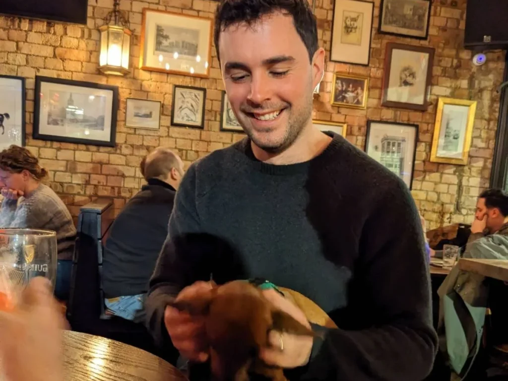 David holding a small dog in a pub