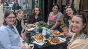 Group of women sat around restaurant table eating