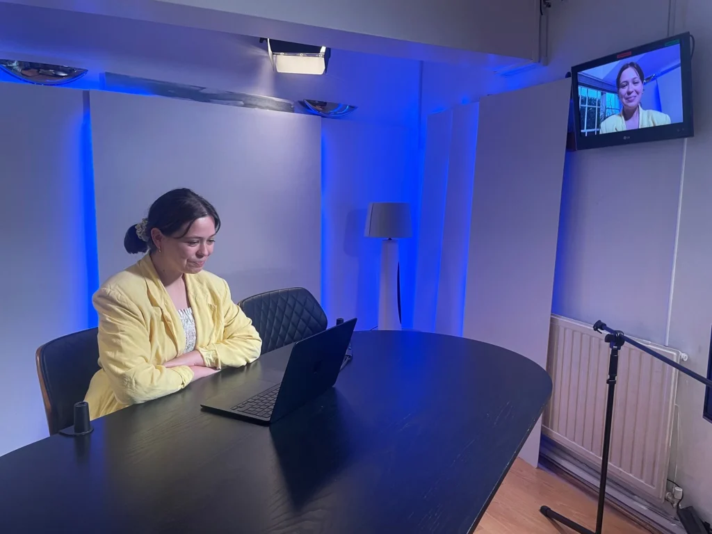 Woman sits at a desk looking at a laptop