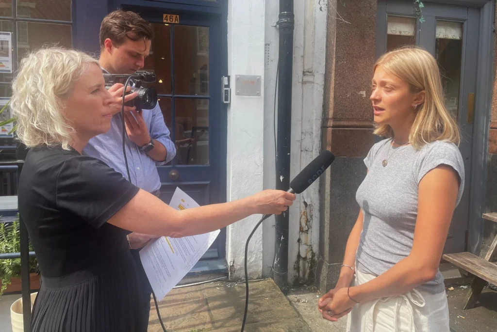 Woman being interviewed and filmed on the street