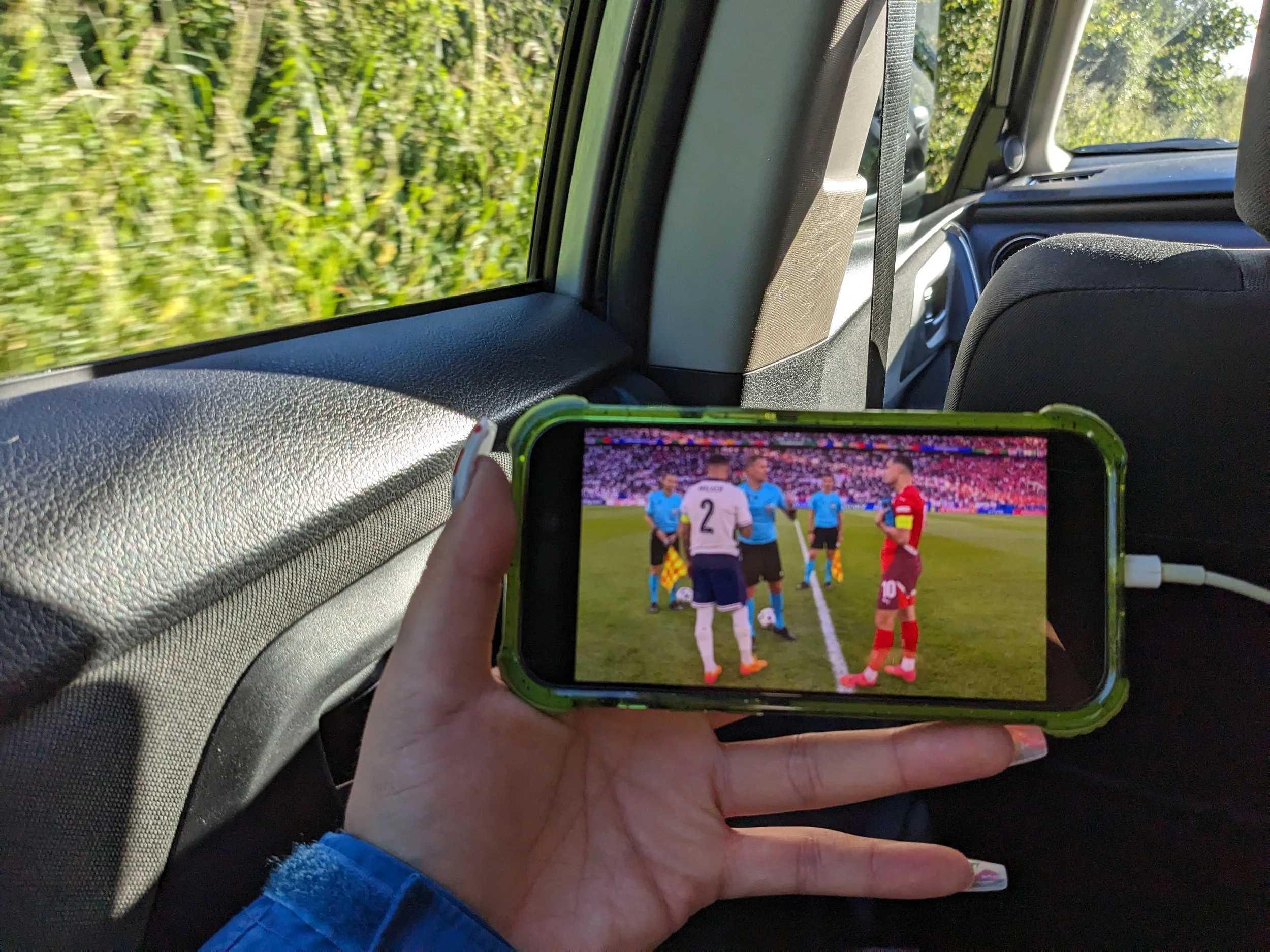 Sabrina watching the Euros in the car on the way to Climate Reframe's Timber Festival.