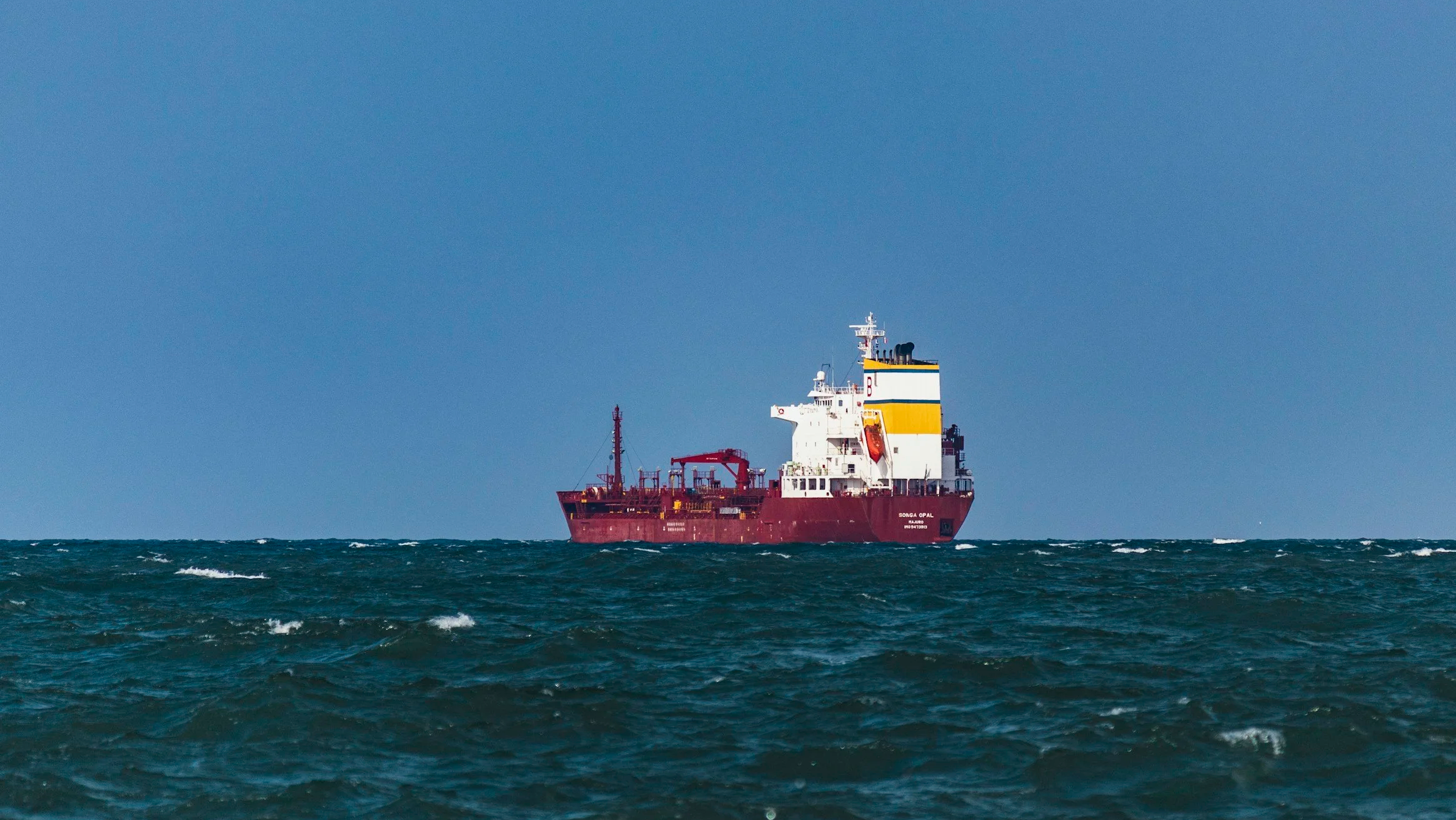 Burgandy red freight ship at sea