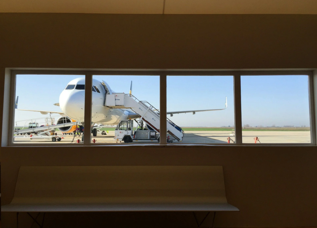A view of a plane on the tarmac through an airport window