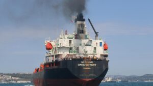 Opec Victory heavy freight ship emitting black smoke near land