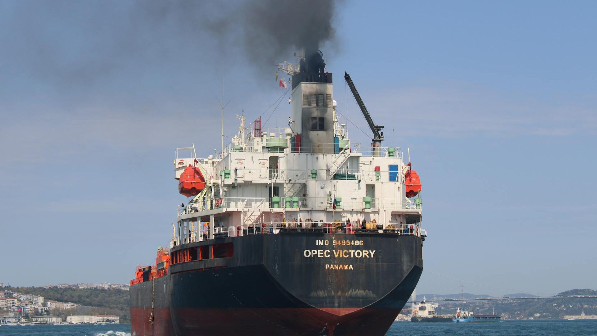 Opec Victory heavy freight ship emitting black smoke near land
