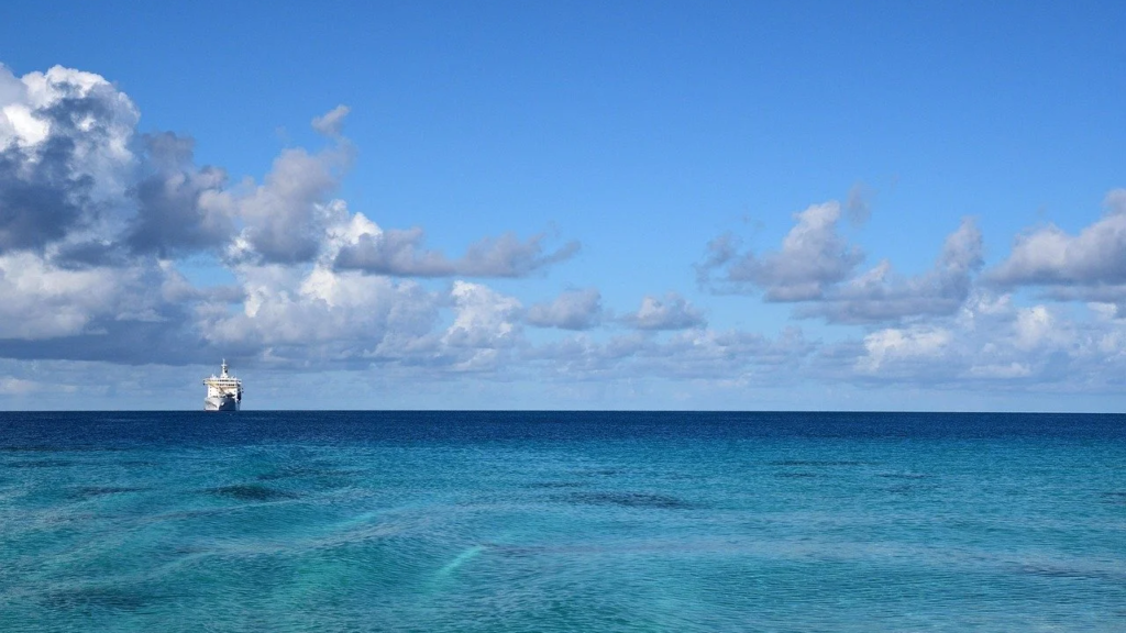 Beautiful summer's day at sea with deep turquoise blue waters and a white ship on the horizon