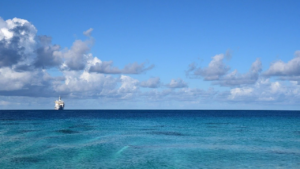 Beautiful summer's day at sea with deep turquoise blue waters and a white ship on the horizon