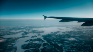 Wing tip of an aeroplane flying above lakes