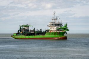 A bright green old cargo ship on the sea