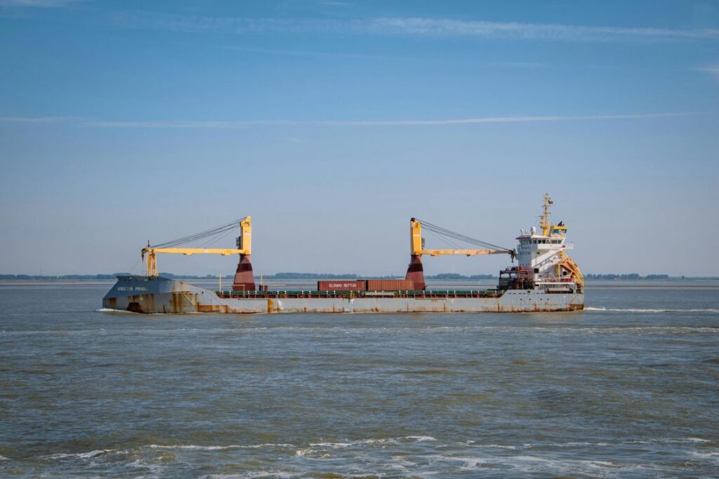 Vessel with red cargo containers at sea