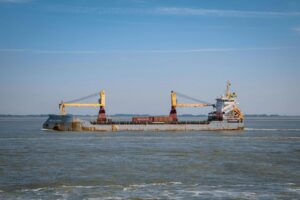 Vessel with red cargo containers at sea