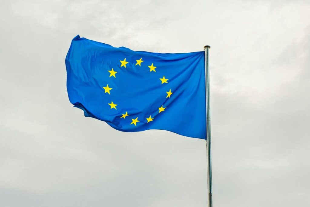 The European Union flag - bright blue with a circle of yellow stars - fluttering in the breeze