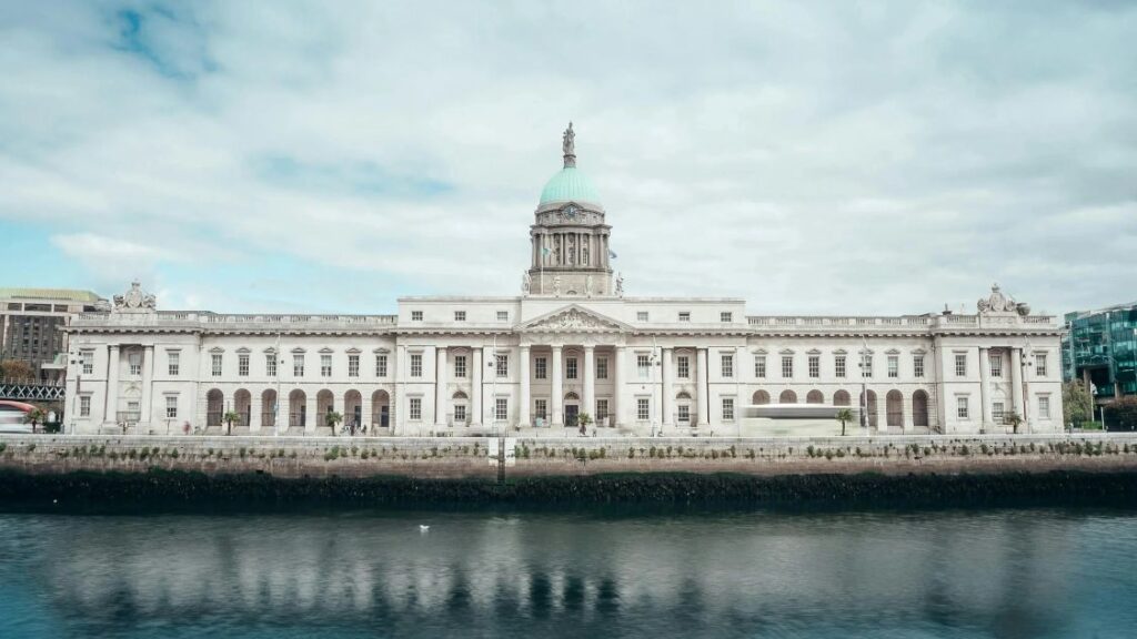 Main facade of Irish government buildings consisting of pillars and a green-domed roof