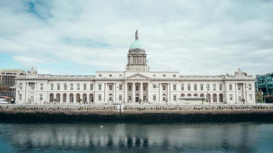Main facade of Irish government buildings consisting of pillars and a green-domed roof