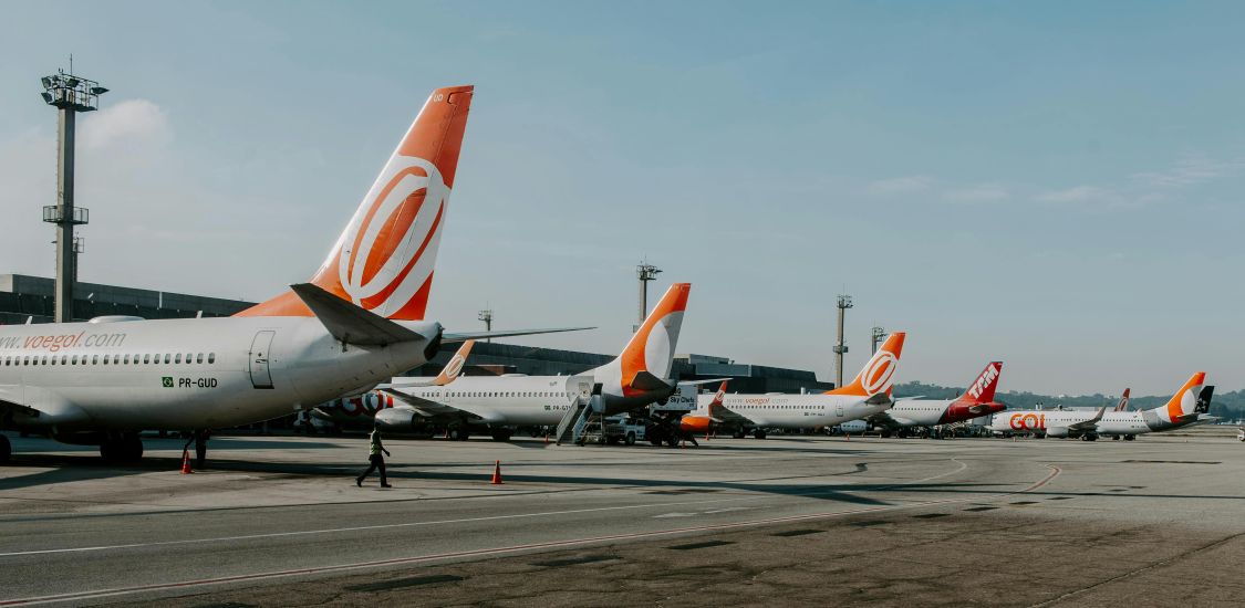 A row of aeroplanes with orange and white rudders waiting at a European airport