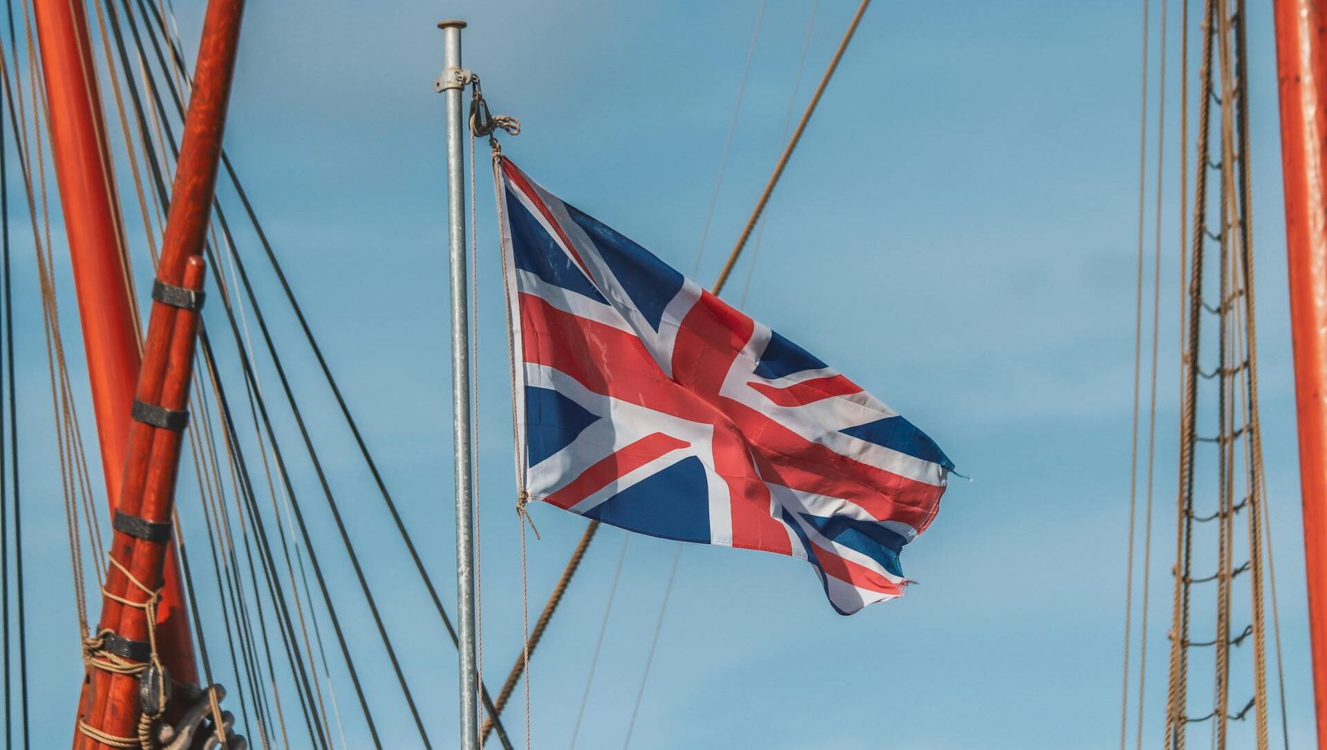 Union Jack flag in sky, surrounded by shipping masts Union Jack flag in sky, surrounded by shipping masts