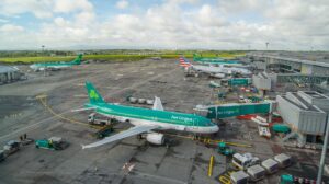 A busy airport terminal featuring Aer Lingus planes