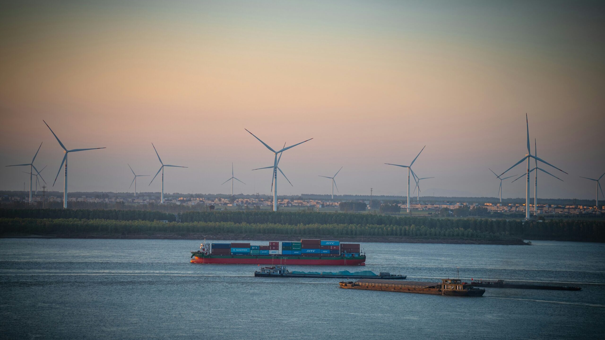 Wind farm by the sea with a cargo vessel adjacent to it